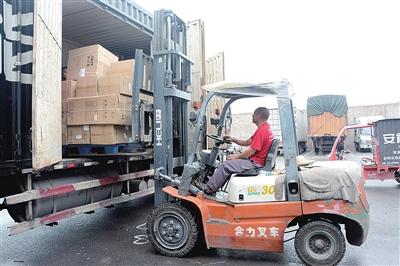 7月30日,在区电商物流公共配送中心,工人正在卸货物.
